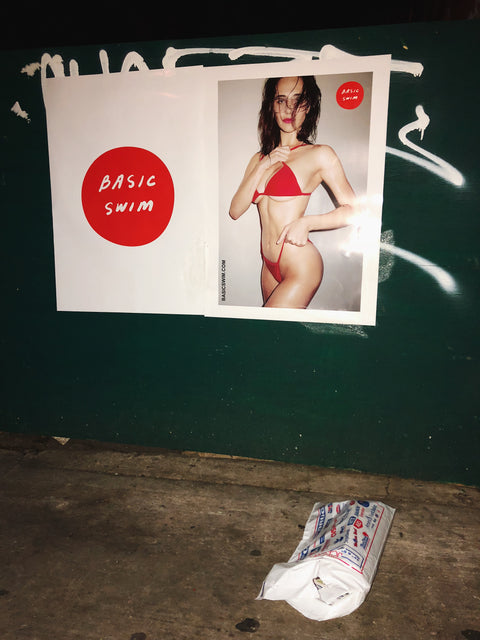 Basic Swim wheat paste campaign image of a girl in the Red La Premiere bikini set